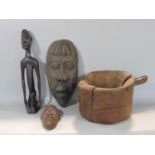 A mixed tribal lot to include a knelt figure of a tribesmen 40 cm high, two wall masks, an unusual