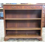 A dwarf freestanding open bookcase with two adjustable shelves beneath two frieze drawers with