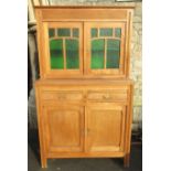 A continental stripped kitchen dresser in two sections, the lower enclosed by a pair of
