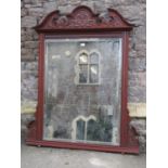 An Edwardian walnut overmantel mirror, the moulded frame with broken arch pediment and scrolling