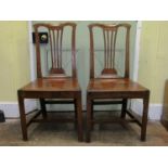 A pair of 18th century oak cottage dining/side chairs of simple form with pierced splats, shaped