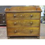 A mid Victorian period mahogany chest of three long graduated drawers beneath a three quarter raised