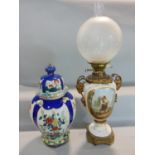 A good quality hand painted porcelain oil lamp, decorated with a panel of gentleman holding a
