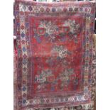 A Persian carpet with red ground, shaped medallion centre and further abstract floral detail, within
