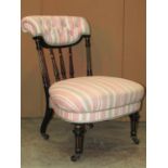 A Victorian nursing chair with gilt highlighted ebonised frame, alternating striped upholstered seat
