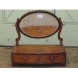A simple Georgian mahogany toilet mirror, the oval mirror plate raised on a bow fronted base