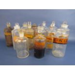 A collection of various clear glass apothecary bottles with original labels and stoppers (13)