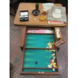 A marquetry games table with fold over top, the quarter veneered cover revealing a baize lined
