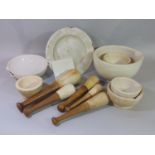 A collection of apothecary related items including graduated pestles and mortars, ointment slab