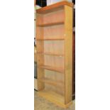 A stripped pine freestanding open bookcase with five fixed shelves 93 cm wide x 26 cm deep x 207