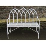 A painted ironwork gothic style two seat garden bench with pierced lancet interlaced back over a
