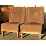 A pair of antique low oak drawing room chairs with upholstered finish raised on square tapered