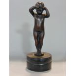 Cast metal (probably bronze) study of a standing crying child, upon a circular plinth, black