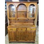 A modern Victorian style pine kitchen dresser, the base enclosed by three panelled doors and three
