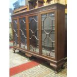 An Edwardian Chippendale revival walnut side cabinet with moulded and blind fret frieze over four