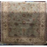 A good quality Persian style wool carpet with pale green ground, decorated with trailing floral