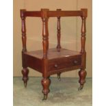 A Victorian mahogany two tier what not incorporating a frieze drawer raised on turned supports