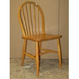 A set of three Ercol light elm and beechwood hoop and stick back dining chairs with simple turned