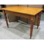 A stained pine kitchen table of rectangular form with end frieze drawer raised on ring turned and