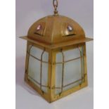 An Arts & Crafts brass hall lantern of square tapered form with frosted glass panels beneath an