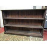 A stained pine dwarf freestanding open bookcase with two fixed shelves, 157 cm wide x 33 cm deep x
