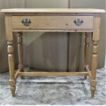 A stripped pine side table fitted with a frieze drawer raised on turned supports united by H