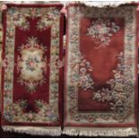 A Chinese washed wool rug with salmon coloured ground and floral embossed panels within a running