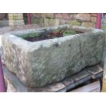 A weathered natural stone trough of rectangular form (cracked), 62 cm long x 41 cm wide x 26 cm in