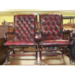 A pair of Georgian style library chairs with scrolled arms, upholstered in button back oxblood red