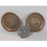Pair of wall dishes of angels carrying cherubs, each 16.5 cm diameter, together with a further