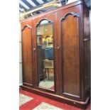 A Victorian mahogany triple wardrobe with simple moulded cornice over three full length panelled