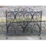 An iron work fire guard of rectangular form with decorative scroll and floral detail, 87 cm wide x