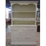 A contemporary cream painted kitchen dresser, the base enclosed by three rectangular panelled