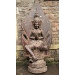 A large contemporary wooden model of an Eastern deity seated on a throne with shaped panelled back