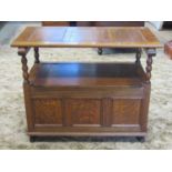 An oak monks bench with sliding rectangular panelled top raised on turned bobbin supports over a