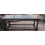 An antique oak refectory table, the plank top with cleated ends over a carved frieze (to all sides),