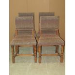 A set of four reproduction Old English style oak framed dining chairs with upholstered seats and