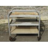 An industrial tubular steel framed three tier trolley, with removeable rectangular trays (one