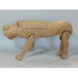 A naive carved timber figure of a lion, with articulated limbs, 50cm long