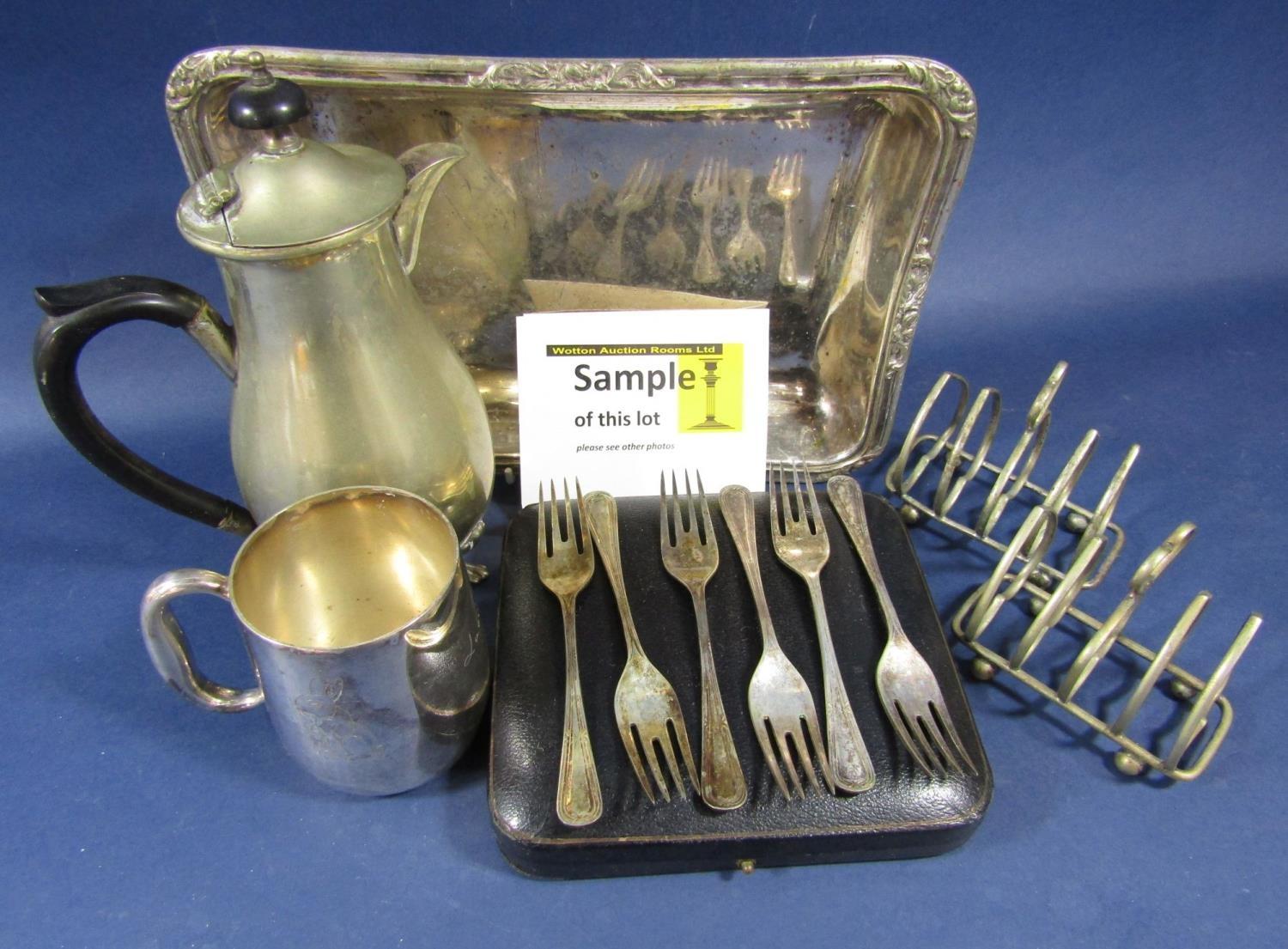 A box containing a collection of silver plated wares comprising lidded entrée dishes, toast racks