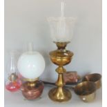 A brass oil lamp with etched glass shade, a further copper oil lamp, two saucepans with steel