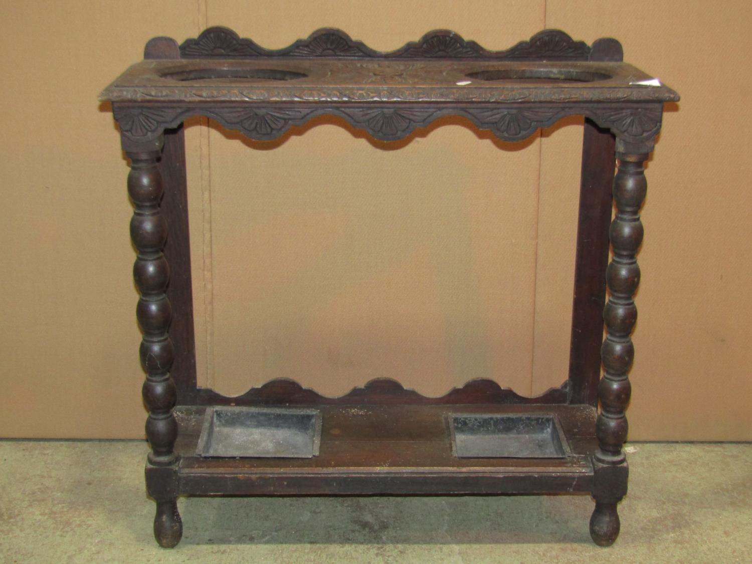 A Victorian Gothic carved oak umbrella/stick stand, with two oval cut out divisions and turned