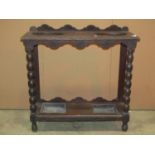 A Victorian Gothic carved oak umbrella/stick stand, with two oval cut out divisions and turned