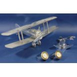 A contemporary model of a bi-plane, a chrome Jaguar Radiator mascot/paperweight and two small gauges