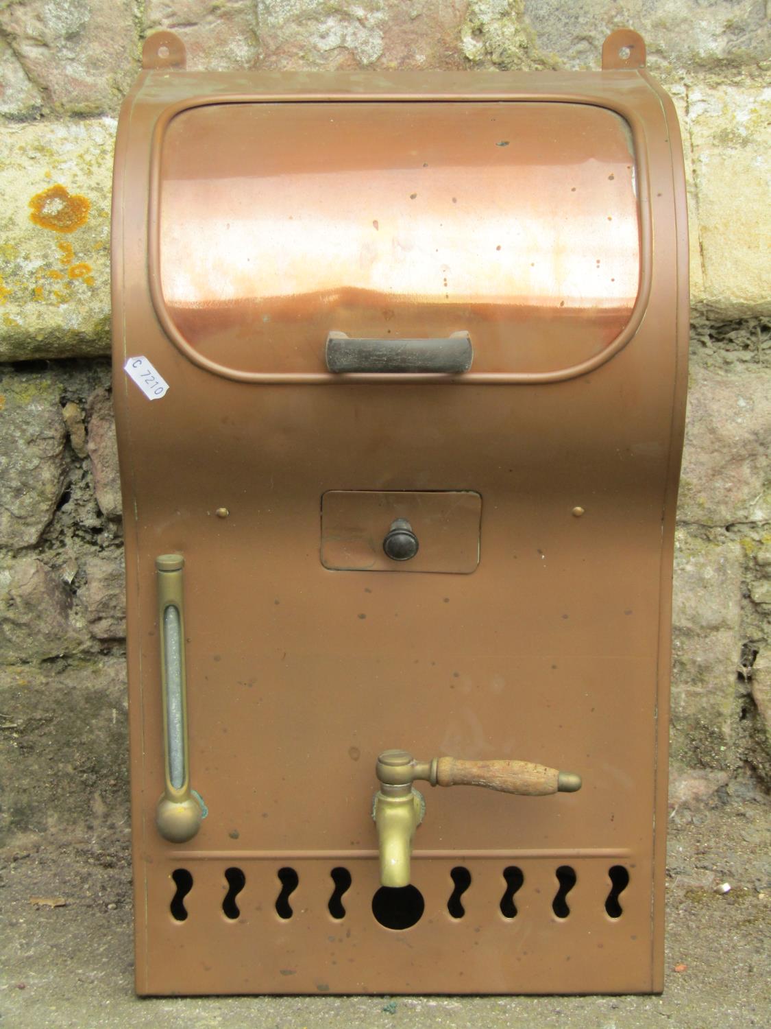A vintage copper wall mounted water heater (?) with brass tap and fittings