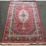 Kashmir rug with scrolled foliate decoration and blue running borders upon a red ground, 300 x 190