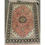Good quality Persian Tabriz rug, the central blue medallion framed by scrolled foliage upon a salmon