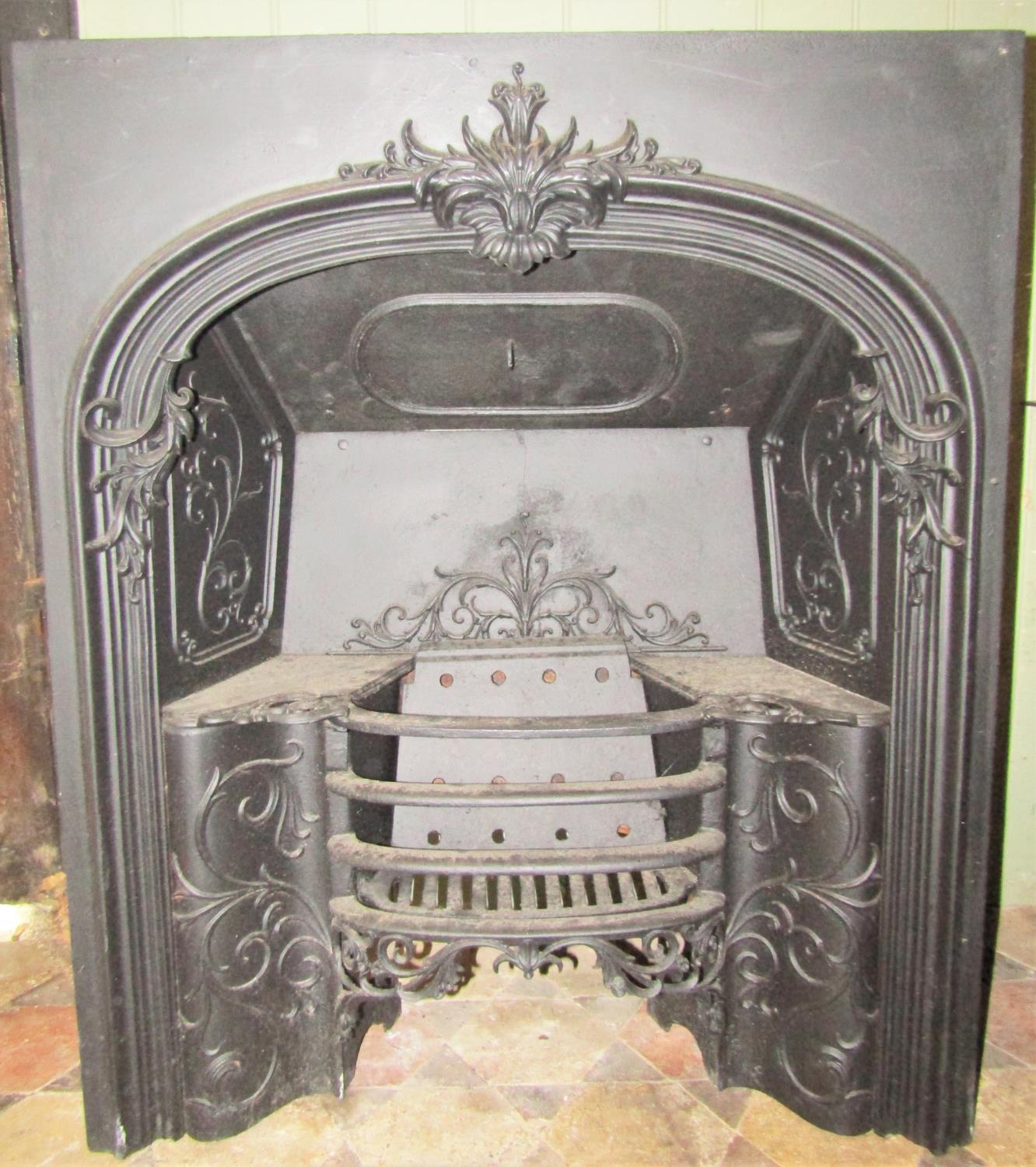 A 19th century cast iron fire insert with scrolling acanthus relief, shallow bowfronted basket and