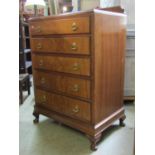 A figured walnut veneered bedroom chest of five long graduated drawers raised on squat cabriole