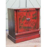 A small Chinese crimson lacquered cabinet enclosed by two doors, with chinoiserie detail, 47cm